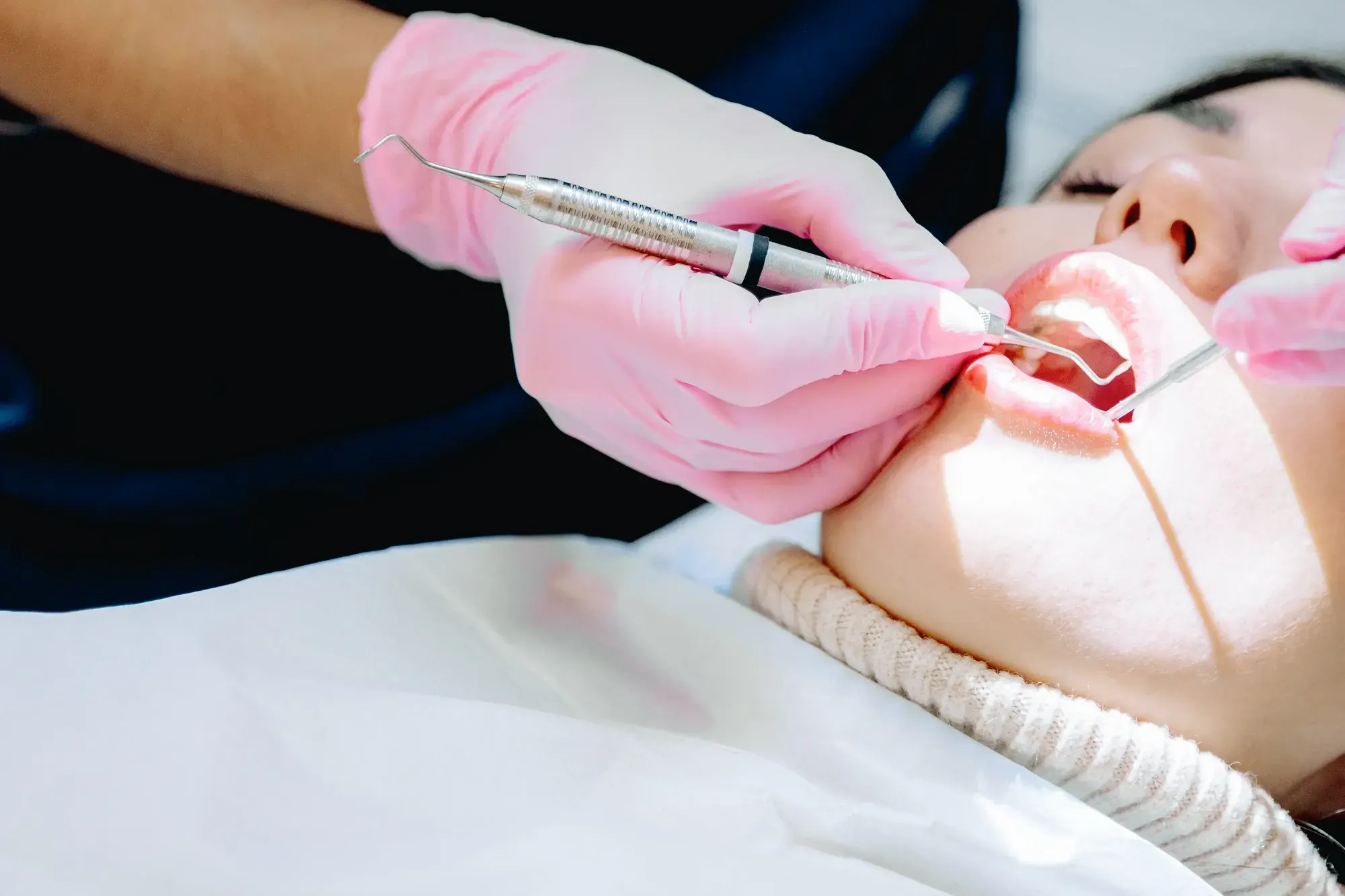 Dental professional checking a patient’s gums during a periodontal exam for gum disease treatment in Tribeca